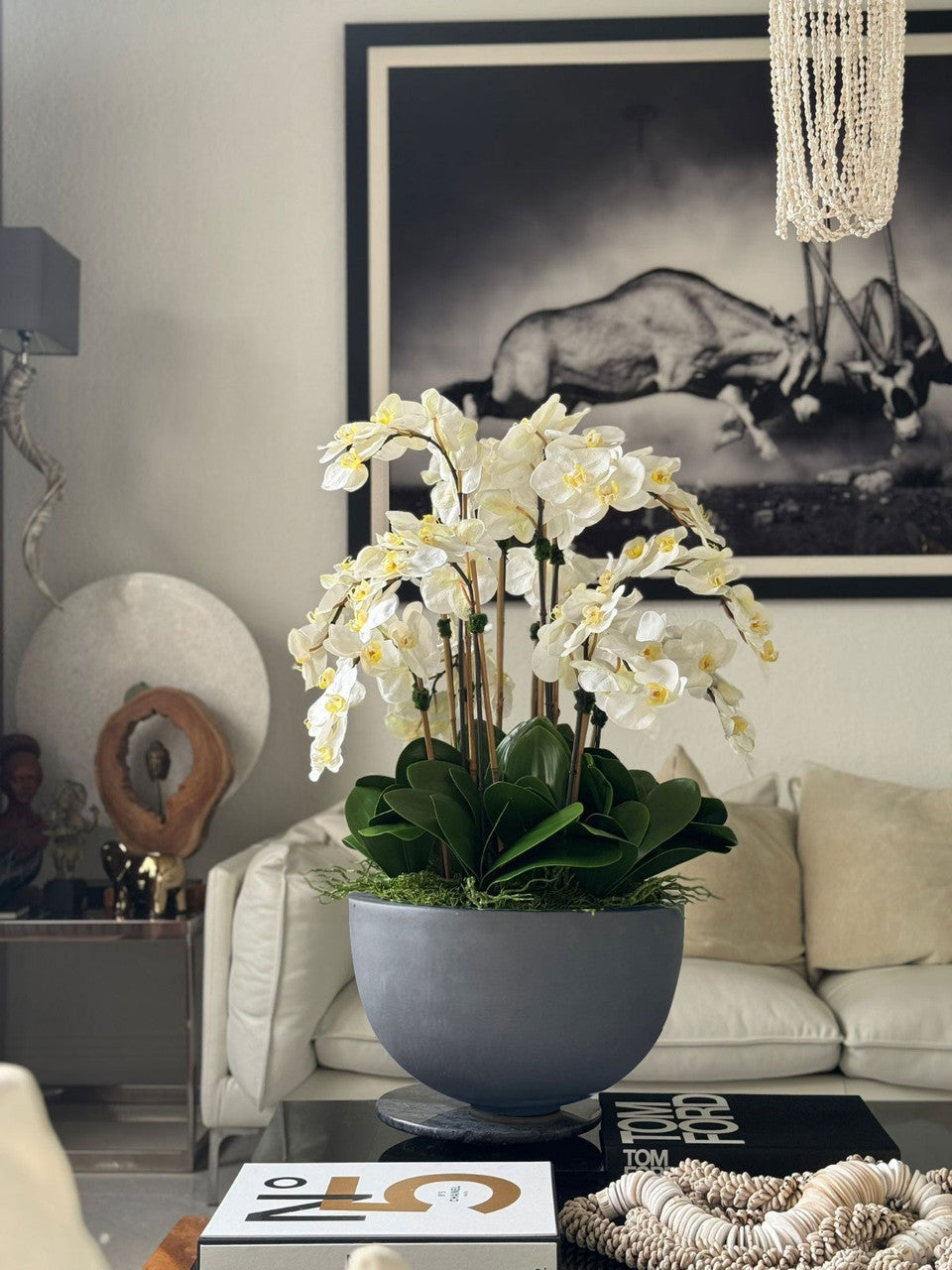 Orchidées blanches dans coupe en pierre composite gris brillant